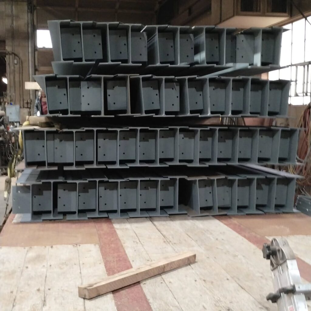 Stacked metal sections are organized in a workshop, showcasing their sturdy design. This image highlights materials likely used in construction.